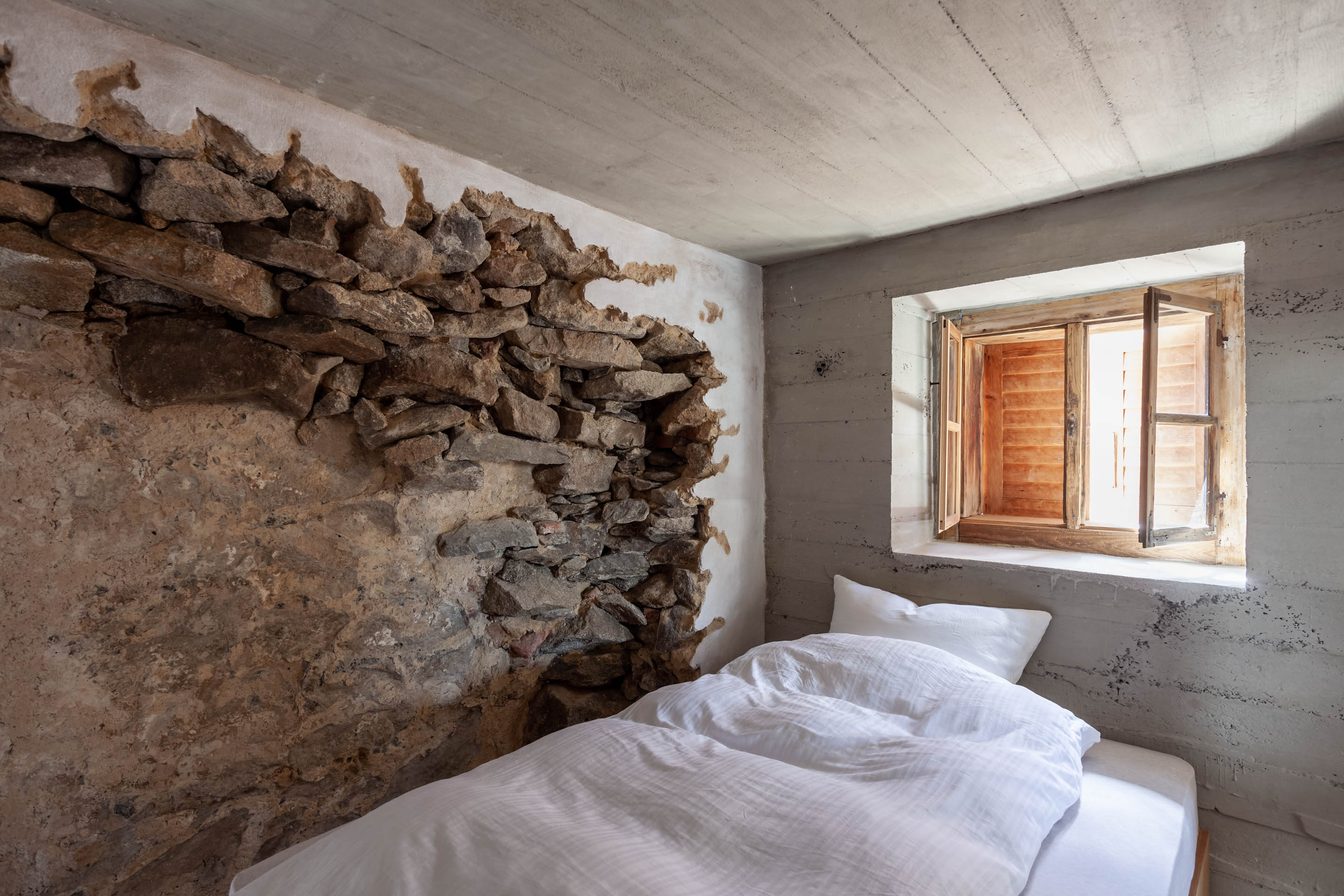 Schlafzimmer im Waidlerhais in Blaibach mit Übergang des alten Bestandgebäudes an die neue Betonschalung